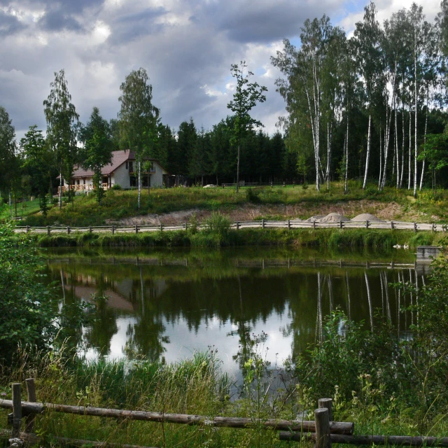 a cabin next to a river with reflections of the water