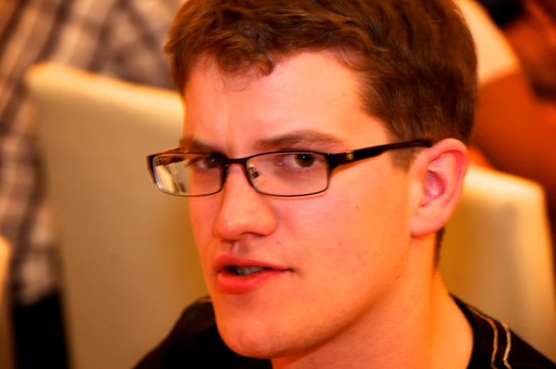 a man wearing glasses and with a beaded collar