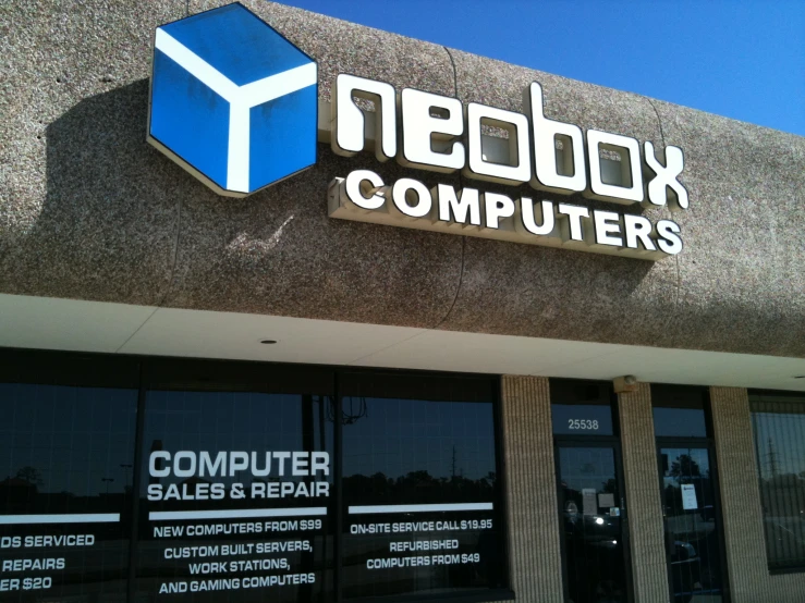 a computer shop with windows and a blue logo