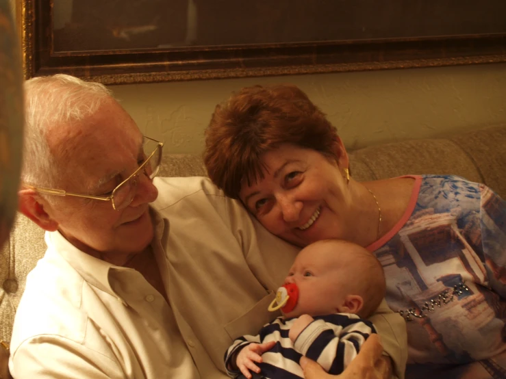 a man holding a baby, smiling at the camera