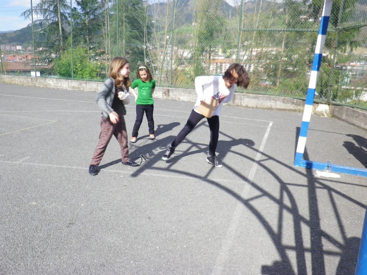 three girls stand together in a parking lot