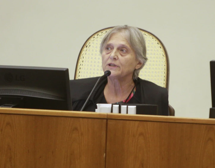 an older woman speaks into her computer monitor