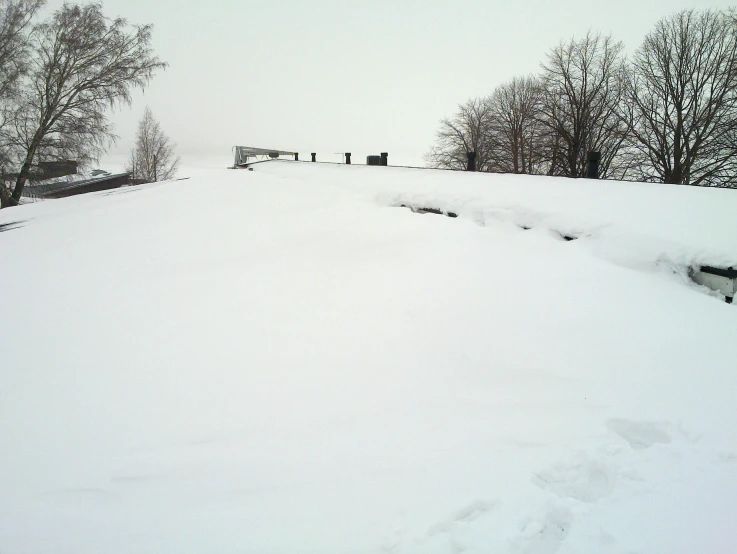 a snow covered hill with trees in the distance