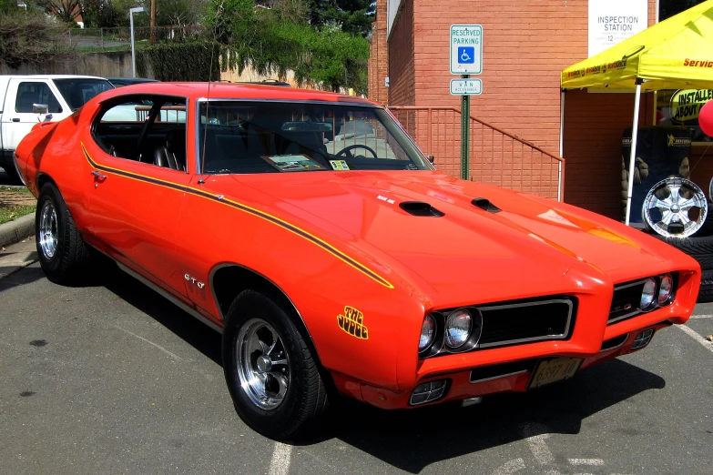 an orange pontiac on display at a car show