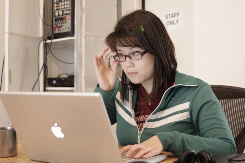 a woman sitting at a table using a laptop computer