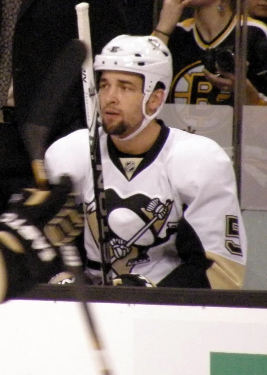 an ice hockey player on the bench waiting for his turn