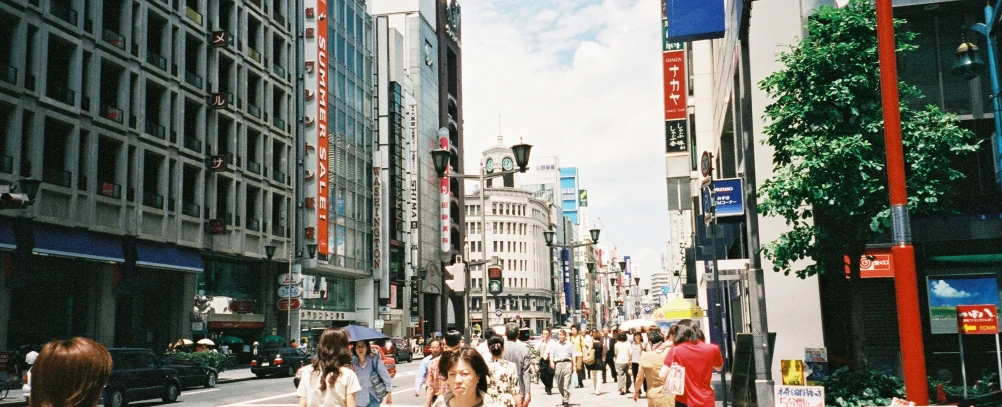 a crowded city sidewalk with people walking and on sidewalks