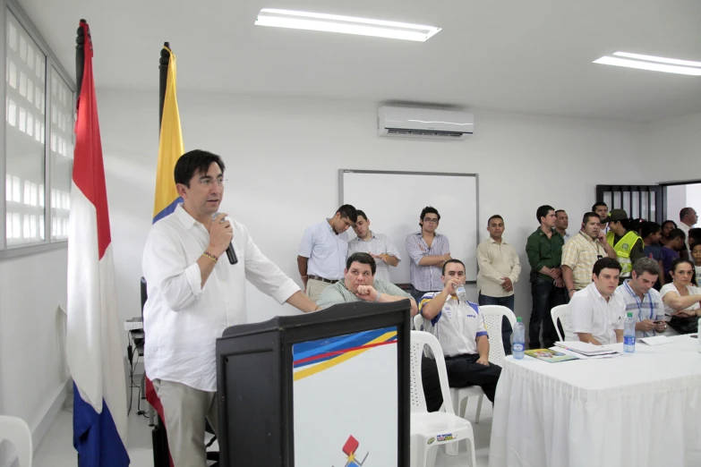 people at a conference and one man standing up giving a presentation