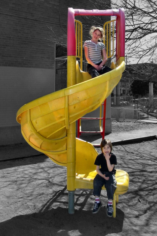 two young children sitting on the slide