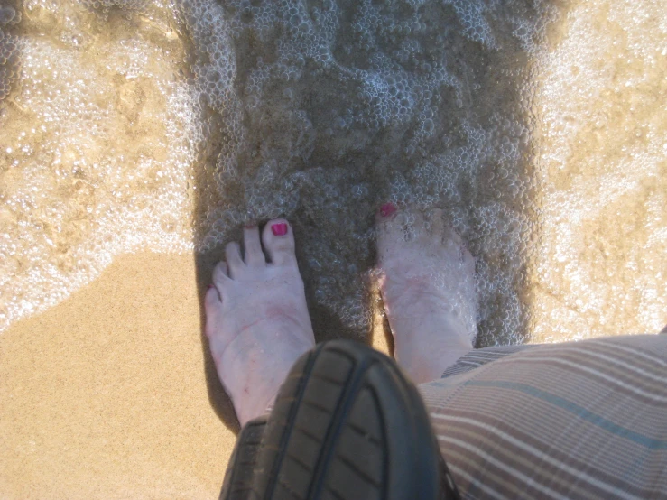 someone is walking around on the sand and feet