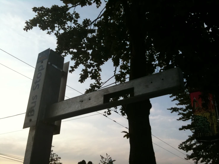 a wooden street sign sitting next to a tree