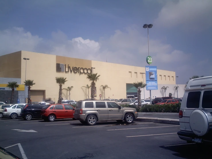 vehicles are parked in the lot near a store