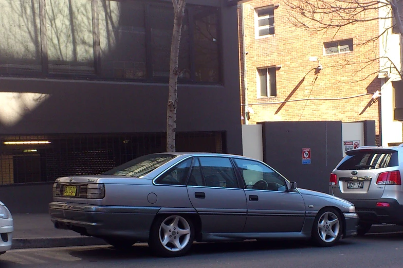 a parked grey car sitting next to a building
