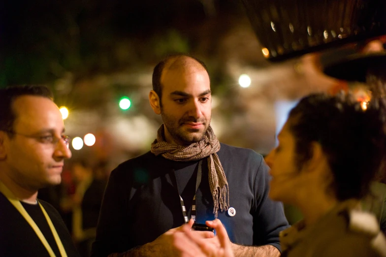 man wearing a scarf holding up his phone