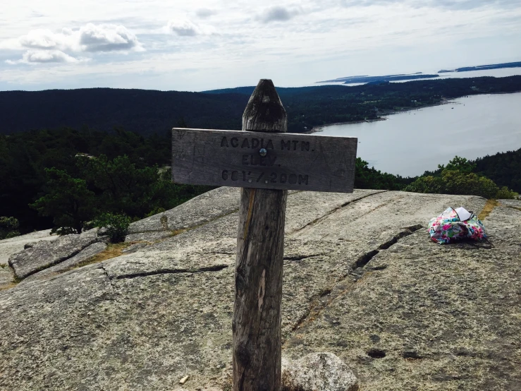 the cross is on top of a mountain with a lake in the background