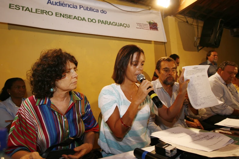 a group of people talking into microphones sitting down