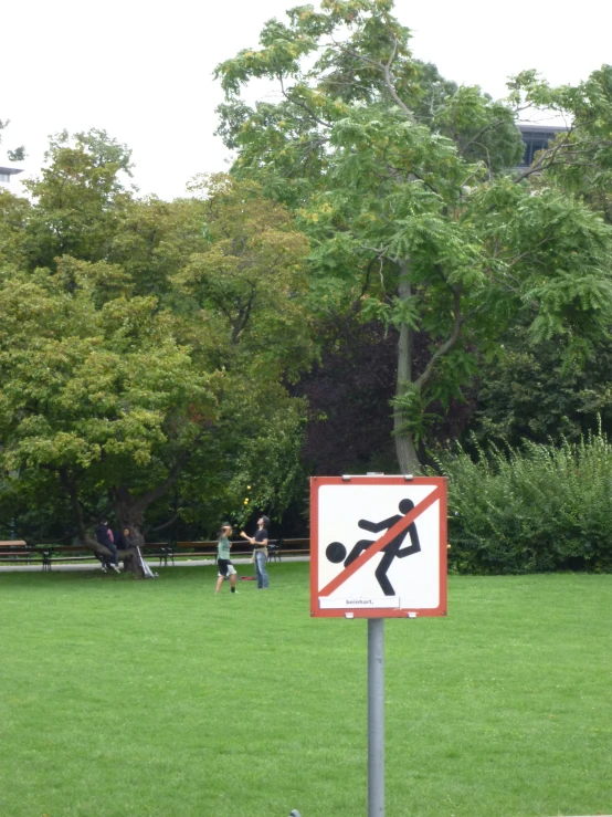 there are two people in the park near this sign