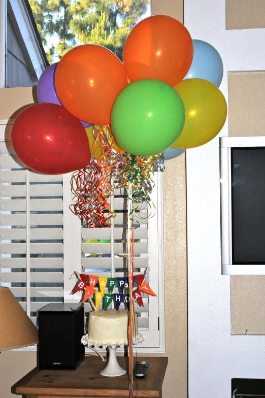 the multi colored balloons are on the table