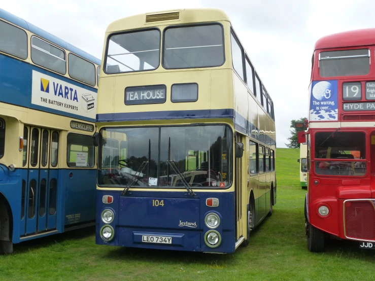 two double decker buses parked in front of another bus