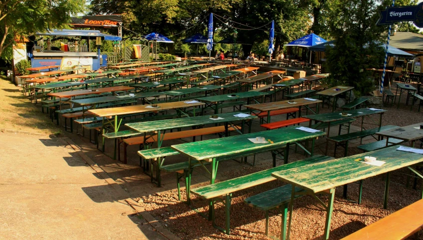 a bunch of tables with some green wooden tops