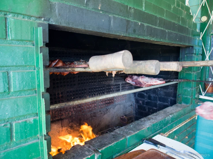 some food is cooking in an oven with flaming tongues