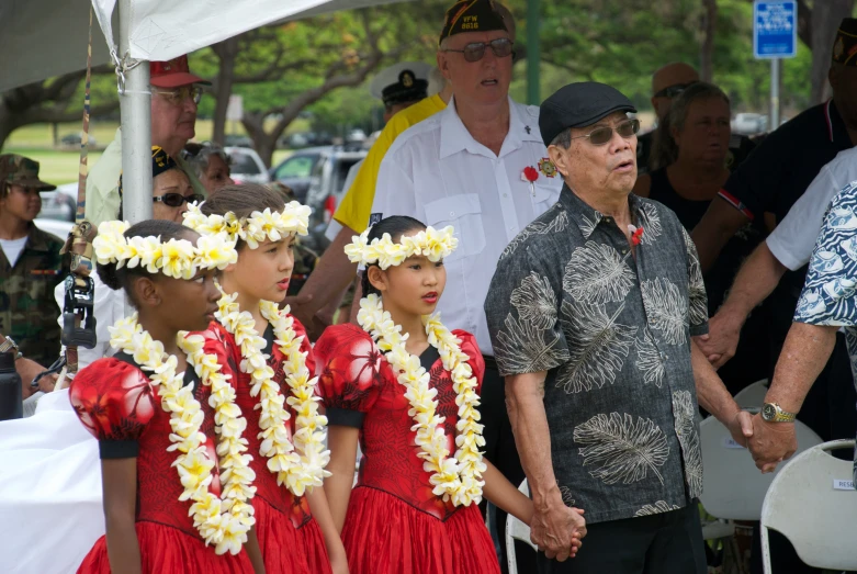 some people are standing in line and one is wearing a flower lei