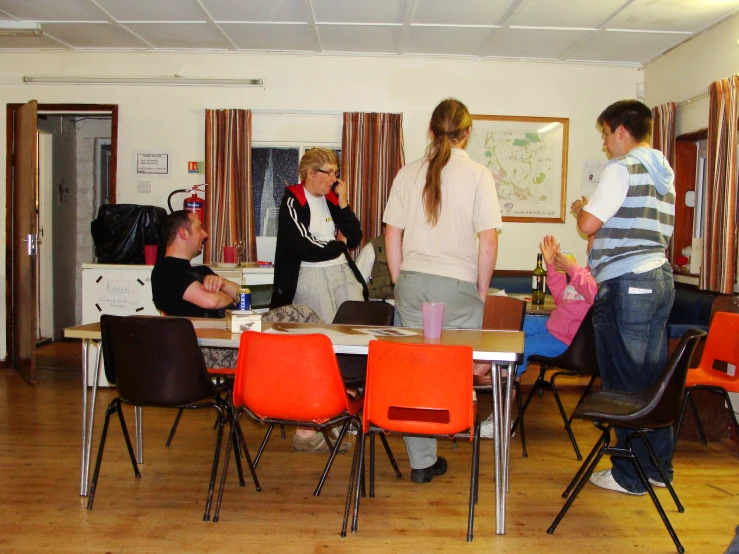 five people are standing around a table with chairs