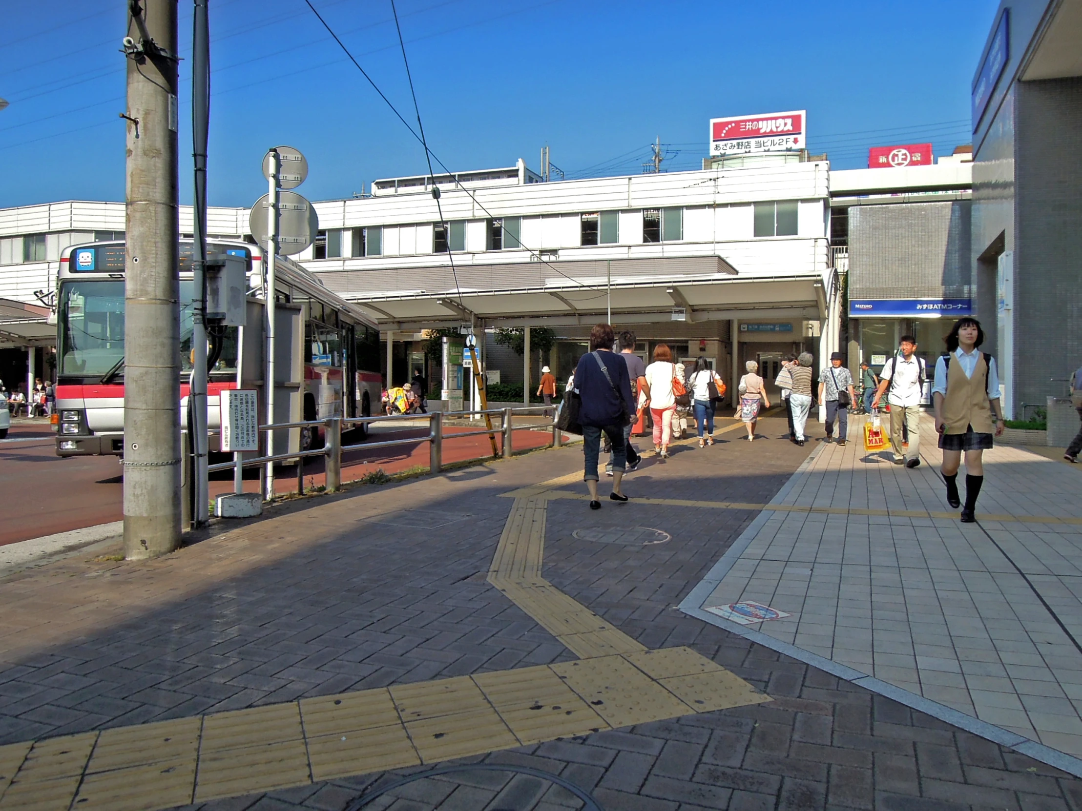 people walk on the side of a city street