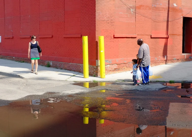 a reflection of a woman and a man walking down a sidewalk