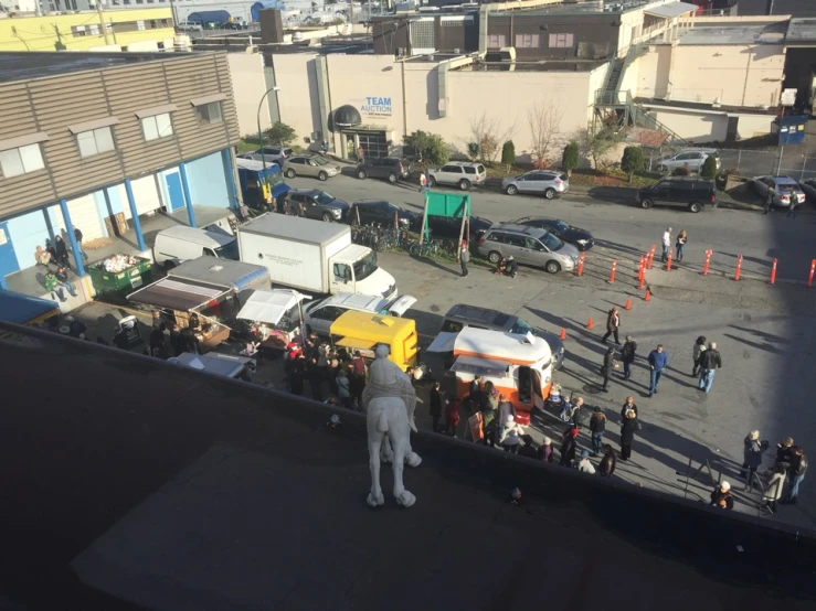 an elevated view of a car show area in front of tall buildings