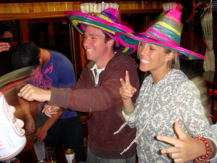 three people are standing with hats on their heads