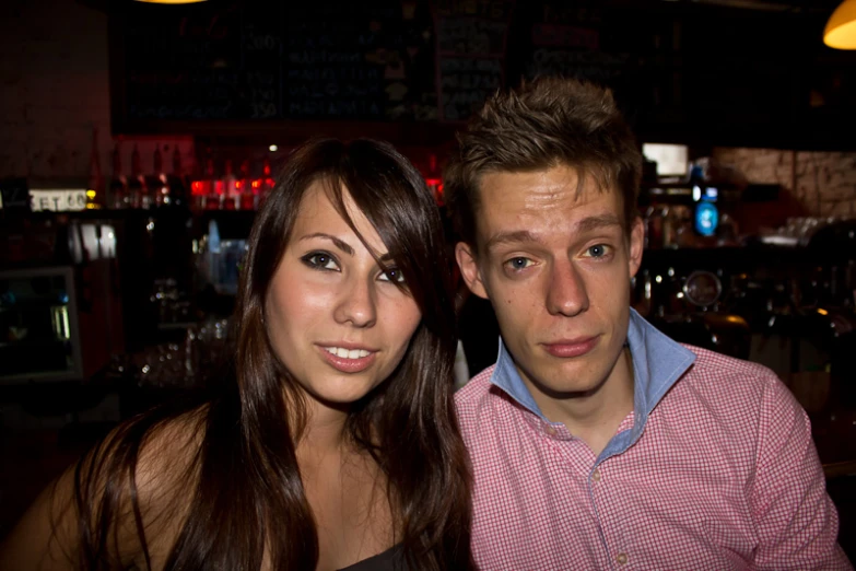 a beautiful young woman sitting next to a man