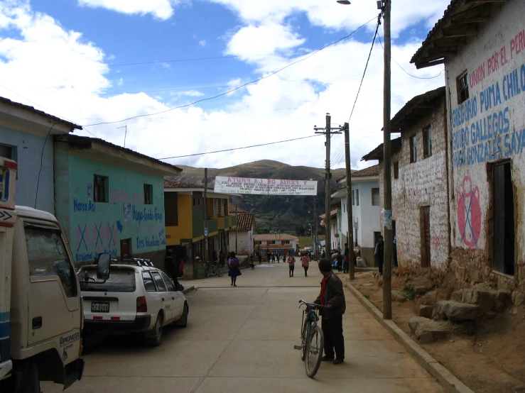 a man stands with his bike on the narrow city street