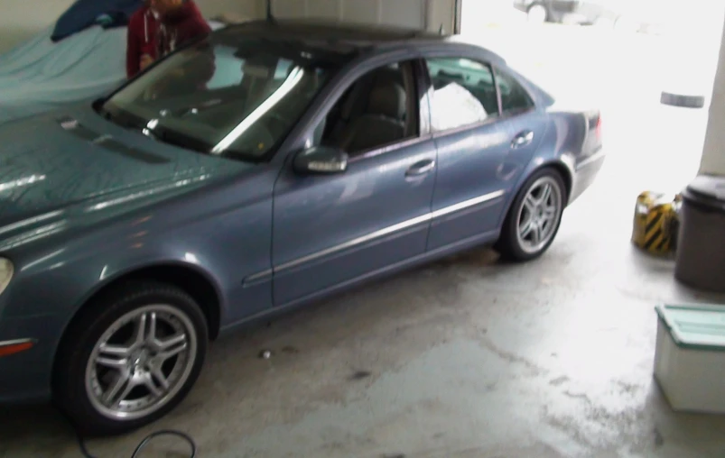 a car is parked in a garage next to another car