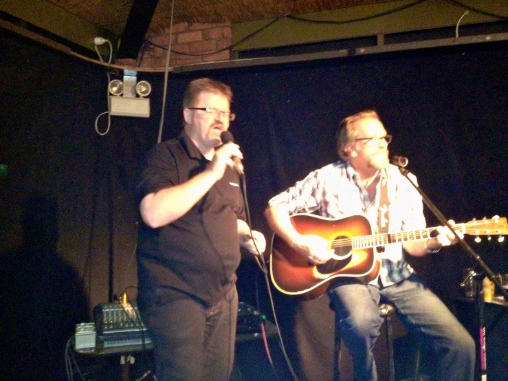 a man and a man are singing on stage