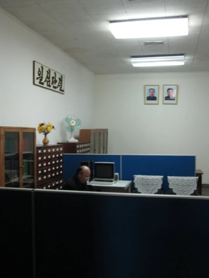 an empty office with a man sitting in the middle of the cubicle