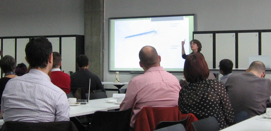 a group of people sitting in front of a projector screen