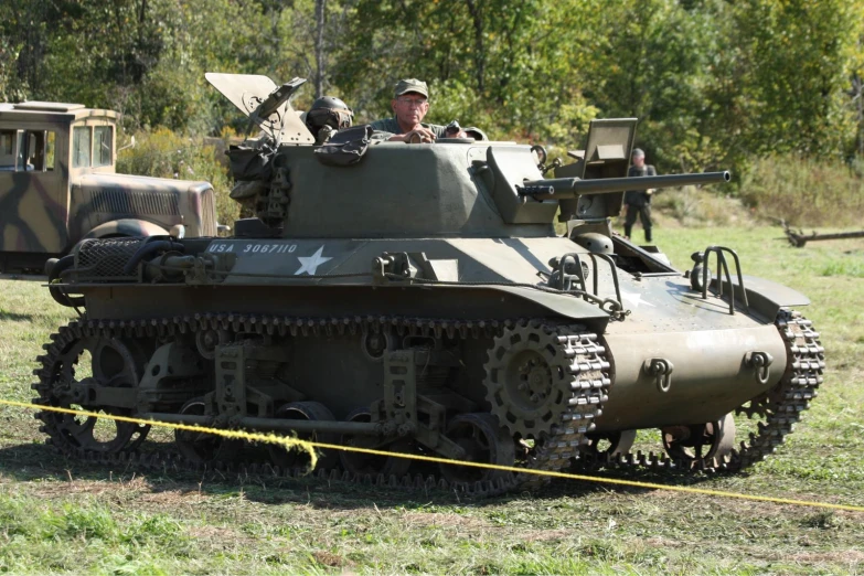 two military men sitting on top of an old army tank