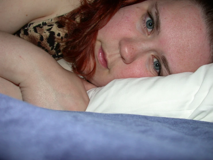 a woman lays down on her stomach in bed