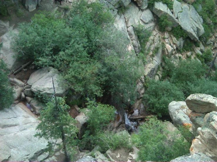 a mountain scene has rocks and a small stream