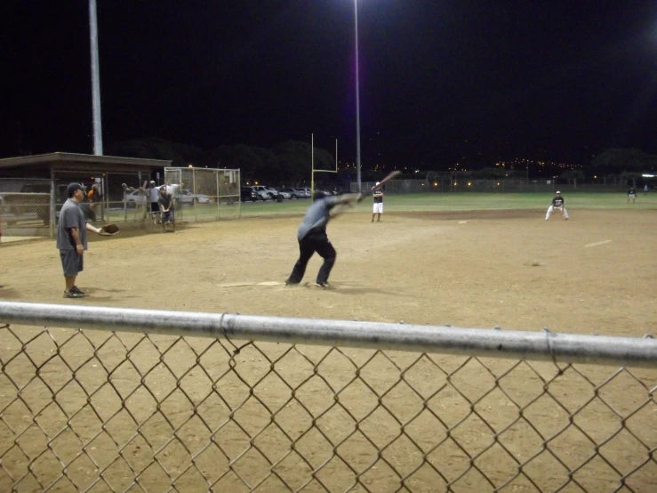 a group of people standing on a field playing baseball