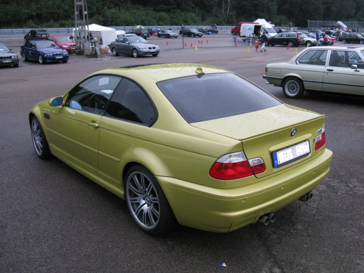 a bright yellow bmw is parked in a parking lot