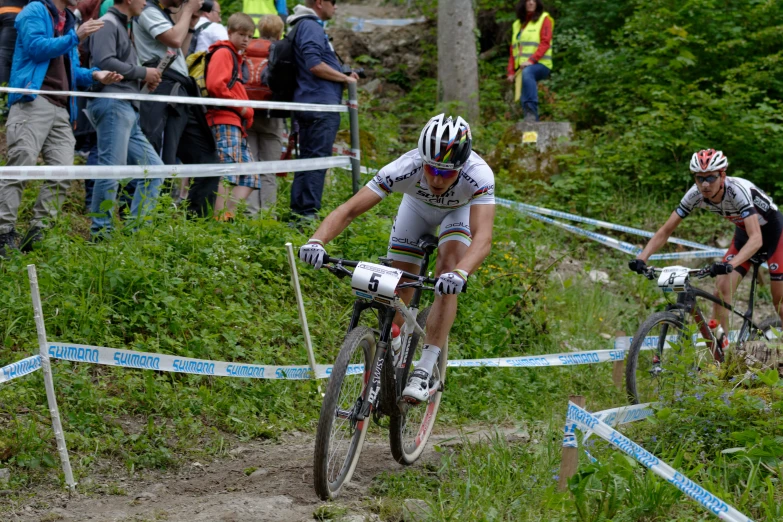 some cyclists are riding on a trail in the woods