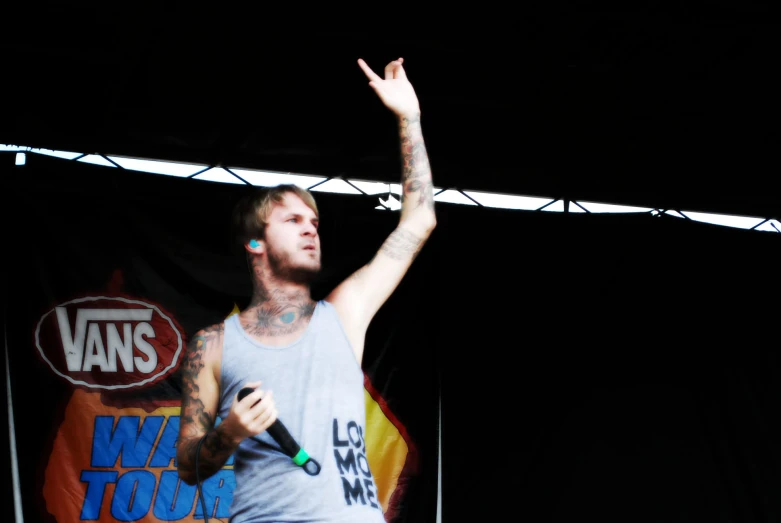 a man holding up a hand and a bottle on stage