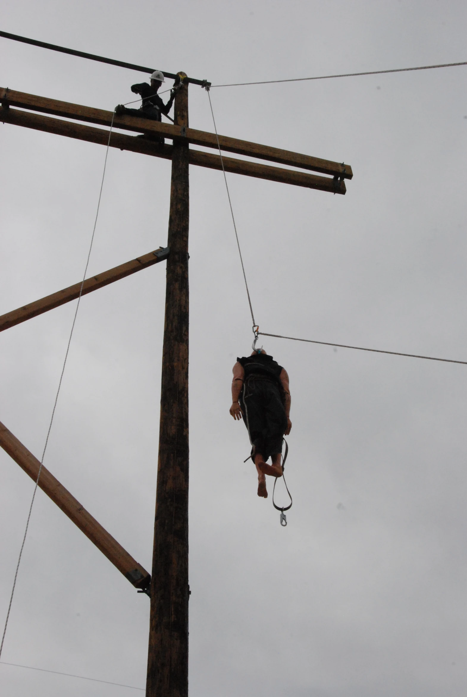 a man on a power line hanging on to ropes