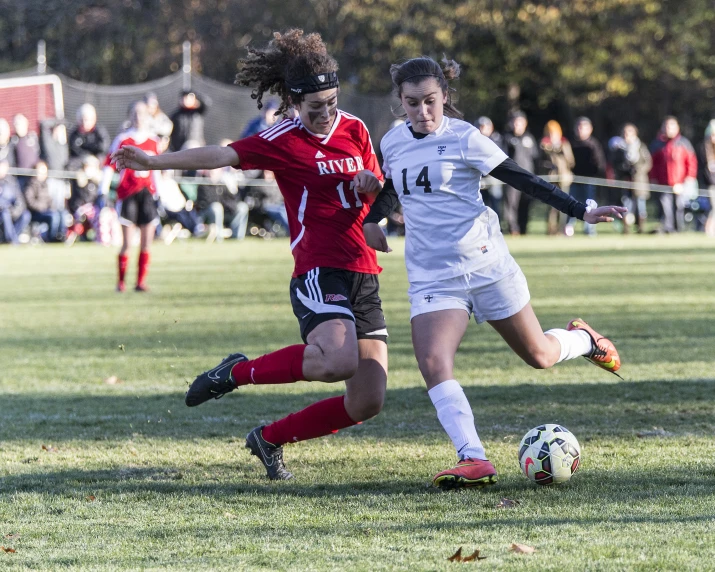 two girls running after the soccer ball during the game