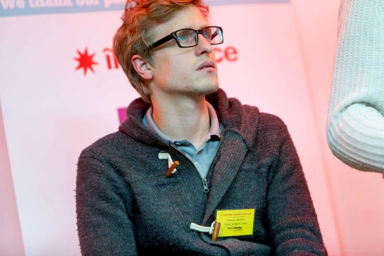 a man wearing glasses and looking into the distance