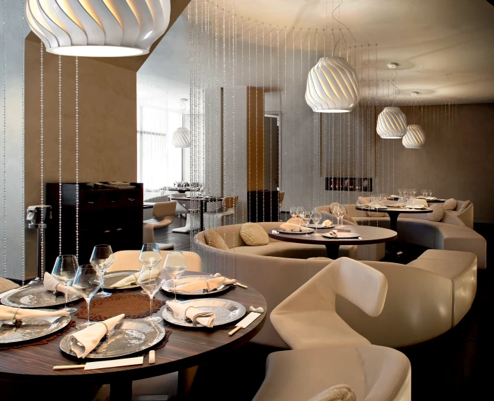 a fancy restaurant set up with white chairs and hanging pearls