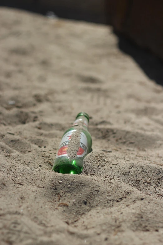 a bottle that is sitting in the sand