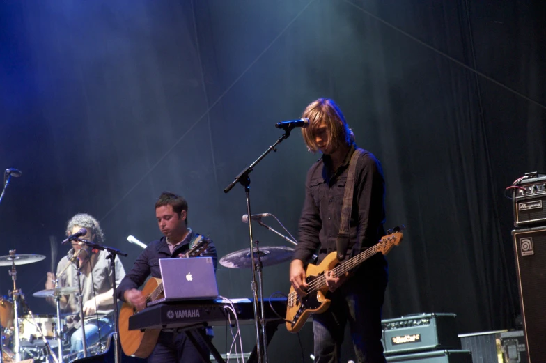 a man standing on stage while holding a guitar